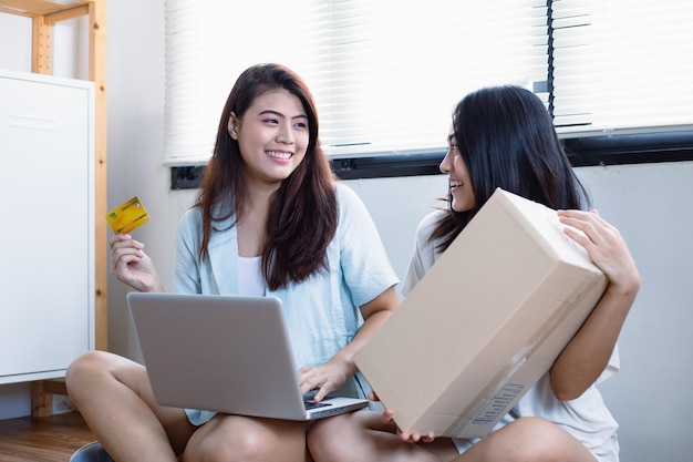 Asian women shopping online using their laptops to find the products