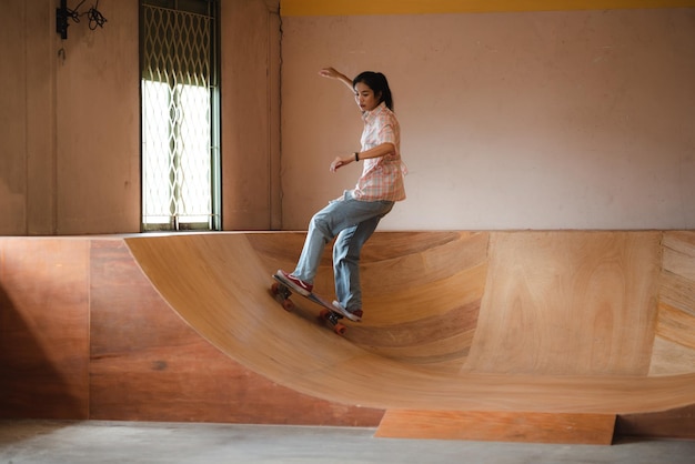 Asian women skater doing tricks jumping in the underground garage Urban activity indoor lifestyle