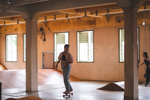 Asian women skater doing tricks jumping in the underground garage Urban activity indoor lifestyle