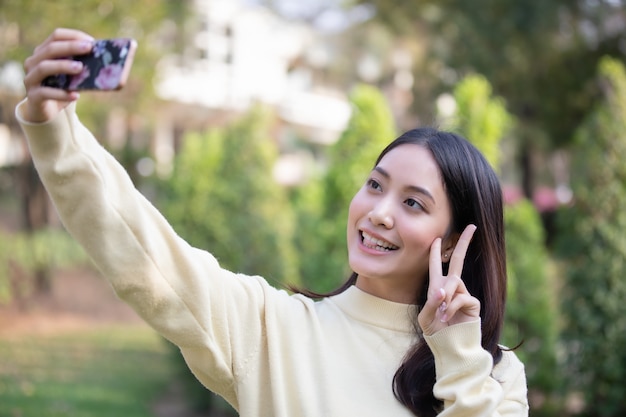 Asian Women smiling are taking photos and Selfie 