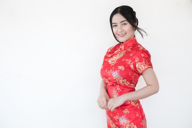 Asian women in traditional Chinese cheongsam with a gesture of congratulations.