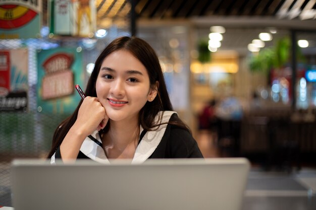 Asian women working and learning online with computer notebook. she smiling and happy