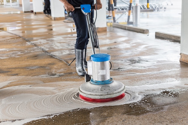 Asian worker cleaning sand wash exterior walkway