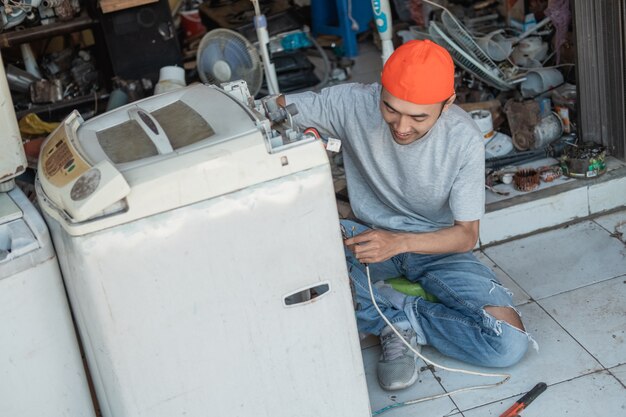 Photo asian  worker fixing broken washing machine wiring