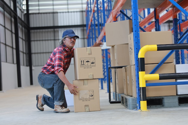 Asian worker man lift heavy box in factory