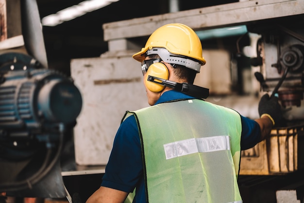 Asian worker man  working in safety work wear with yellow helmet .