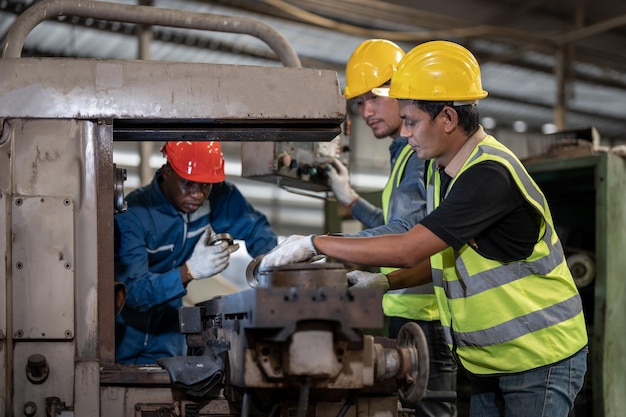 asian workers and african man factory working at steel heavy machine engineering training staff