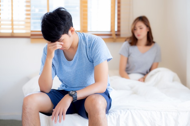 Asian young couple having problem of man worried and unhappy at bedroom