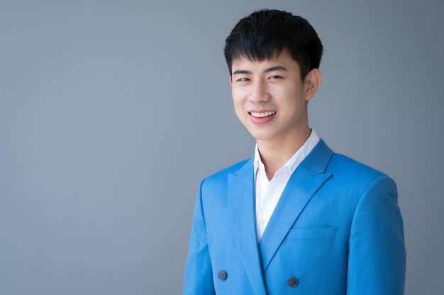 Asian young handsome man smiling in suit