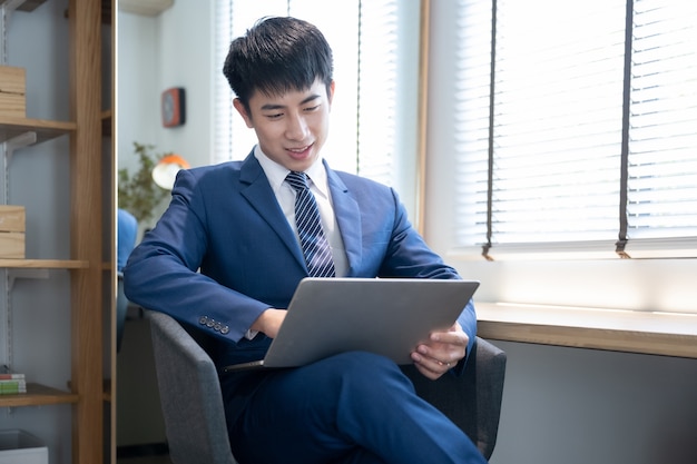 Asian young handsome man using laptop