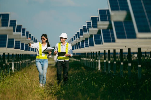 Asian Young Inspector Engineer man and female walking checking operation in solar farm