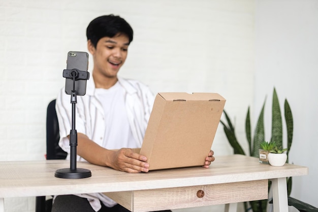 Asian young man in casual style is feeling surprise when unboxing product.