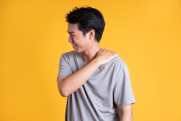 Asian young man posing on a yellow background