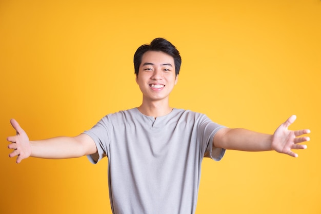 Asian young man posing on a yellow background