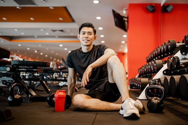 Asian young man sitting rest after workout for good healthy in fitness Lifestyle and sport exercise concept