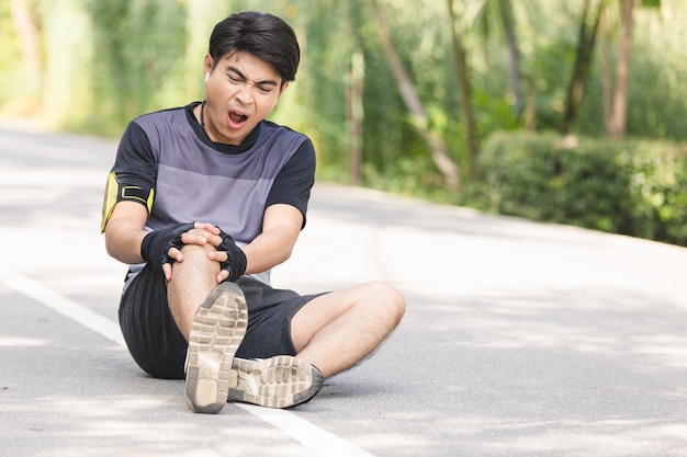 Asian young sport man knee injury from jogging