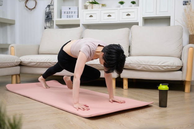 An Asian young woman is workout on fitness mat exercise at home healthy lifestyle concept