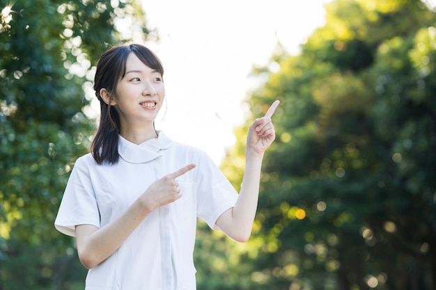 Asian young woman in nurse clothes and posing with hands