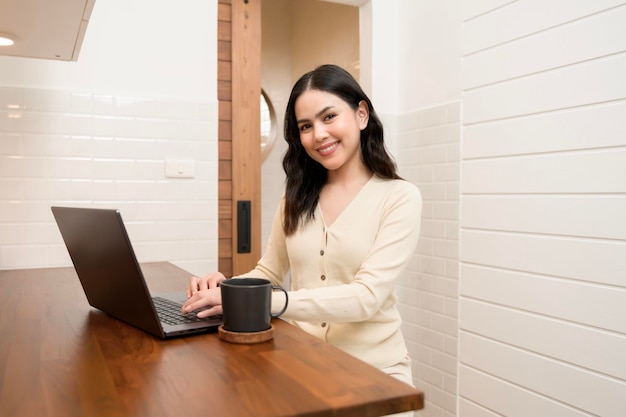 An Asian young woman using laptop computer online working at home lifestyle and teleworking concept