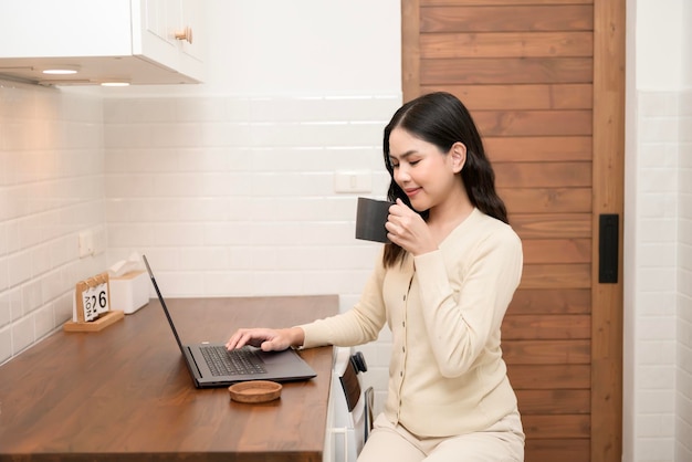 An Asian young woman using laptop computer online working at home lifestyle and teleworking concept