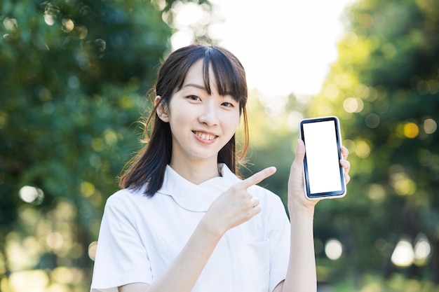 Asian young woman in white clothes with a smartphone