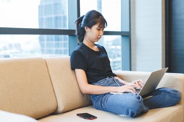 Asian young woman working with laptop from home freelance work job