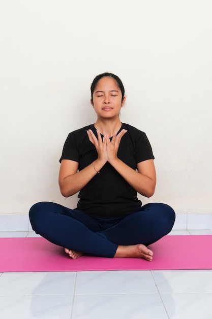 Asian young women doing yoga meditation above sport mattress