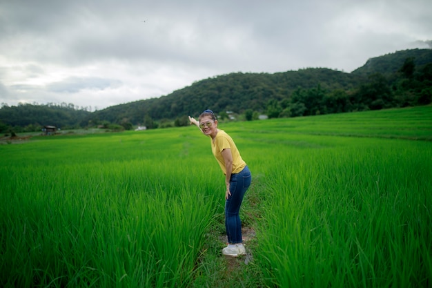 Asina woman standing with relaxing in green rice field