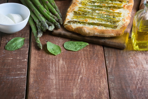 Asparagus green pizza with herbs and mozzarella background