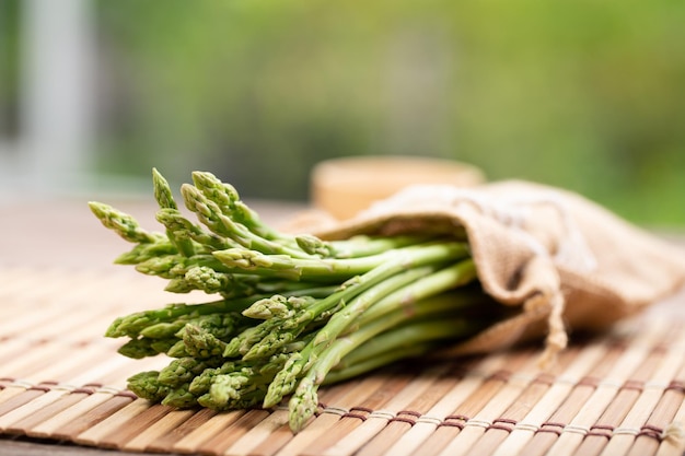 Asparagus is green and straight vegetable Fresh green asparagus is crispy for cook on wood table with salt