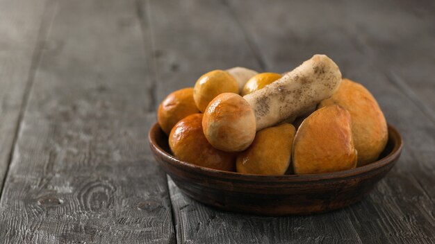 Aspen from the forest in a clay bowl on a wooden table. Natural food from the forest.