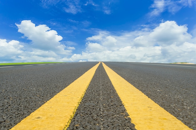 Asphalt pavements and prairies under the blue sky and white clouds