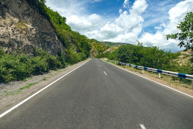 Asphalt road and rocks under sky background