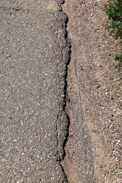 An asphalt road with a lot of holes and damage