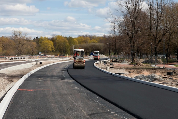 Asphalt rollers paving new asphalt driving in line one near another New road construction Selective focus