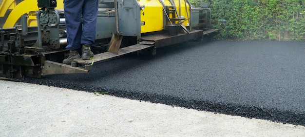 Photo asphalting paver machine during road street repairing works