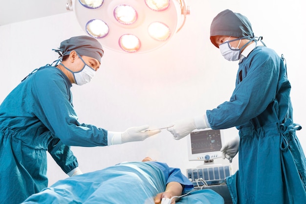 Assistant Hands out Instruments to Surgeons During Operation Surgery and emergency concept