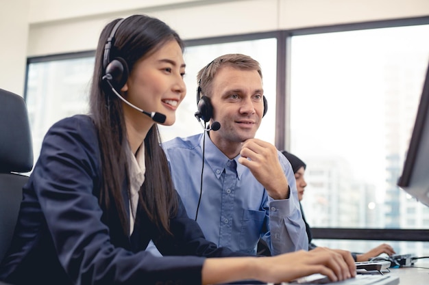 Photo assistant supervising the call center staff in the office. manager assistant staffs in a call center. customer service executive trainer assisting by team at office.