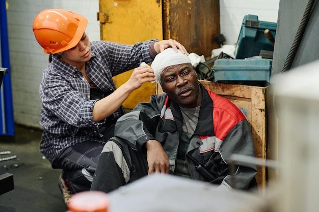 Photo assisting injured colleague in industrial setting