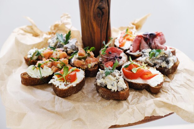 Assorted bruschettas on parchment paper on a wooden stand