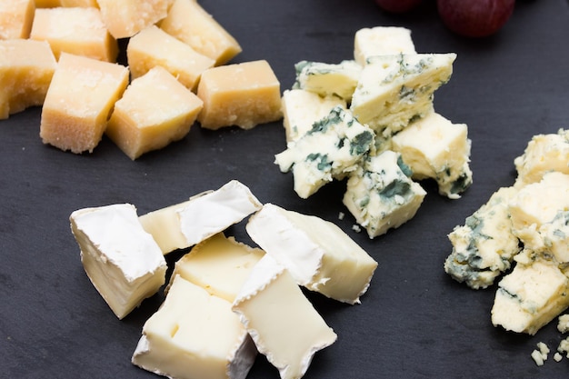 Assorted cheeses on a black plate