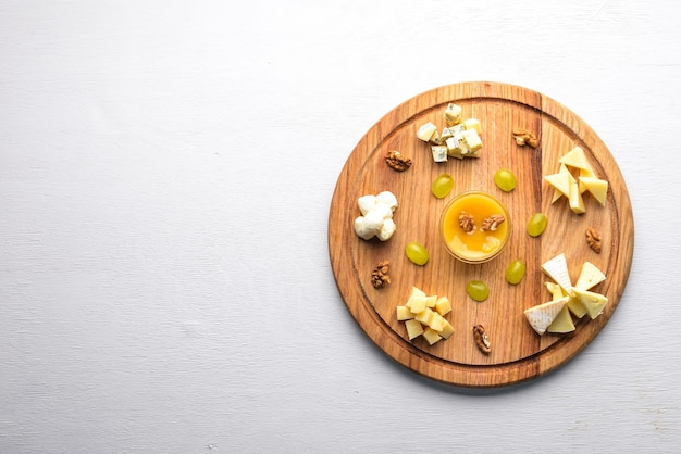 Assorted cheeses gorgonzola brie feta with honey On a wooden background Top view Free space