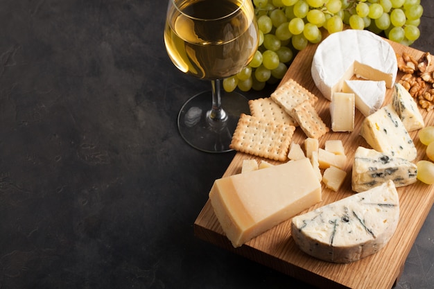 Assorted cheeses with white grapes.