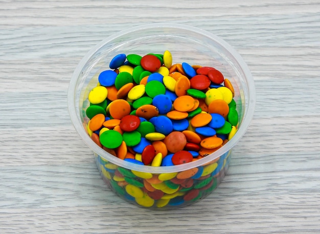 Assorted colorful bunties served in disposable cup side view of indian and pakistani dessert