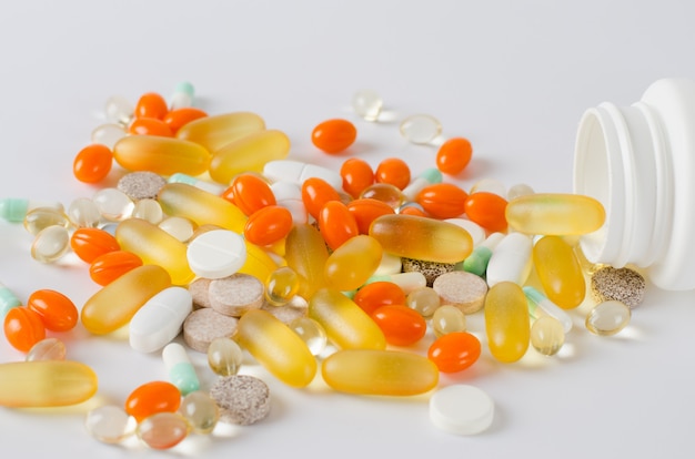 Assorted colorful tablets, pills, drugs on white background. Medication and healthcare concept.