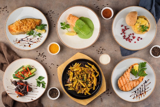 Assorted dishes: fried cod, steamed salmon with spinach, julienne with chicken and mushrooms, beef with cucumbers, fried potatoes with mushrooms, grilled salmon.