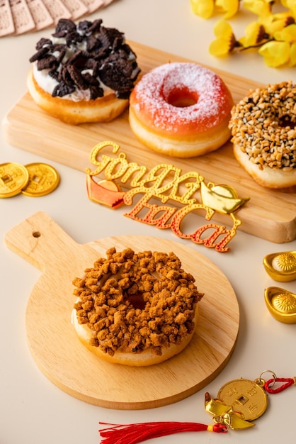 Assorted donuts or doughnut plate on wood tray and shoot in cream background and chinese ornament