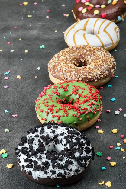 Assorted donuts with icing and feelings on a black background