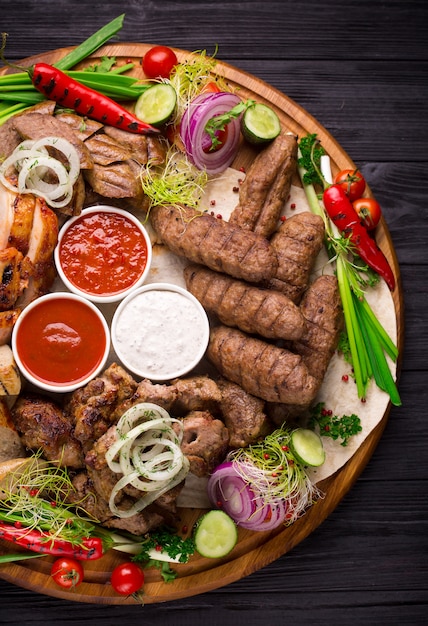 Assorted grilled meat and vegetables on rustic table