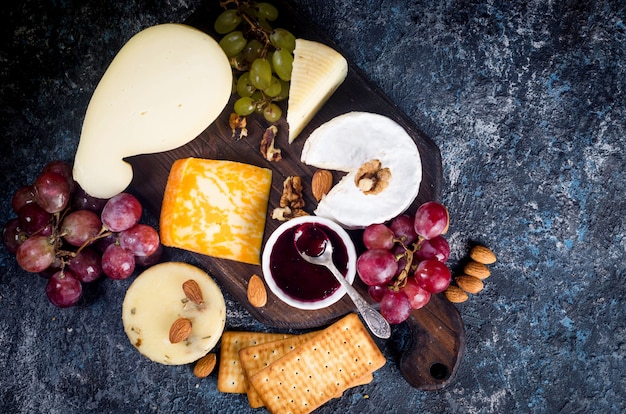 Assorted homemade pieces cheese with jam, grapes, cookies and nuts, cookies and nuts